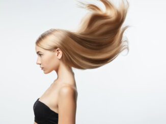 Femme blonde avec les cheveux dans le vent sur un fond blanc