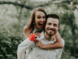 woman riding on back of man