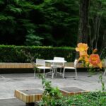 A patio with a table, chairs and flowers