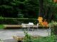 A patio with a table, chairs and flowers