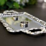 Un plateau en argent contenant deux bagues sur une table sombre