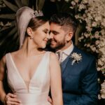 man in blue suit kissing woman in white sleeveless dress