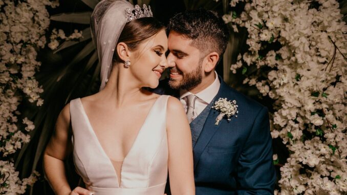 man in blue suit kissing woman in white sleeveless dress